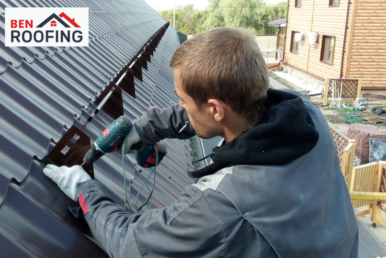 Worker installing a metal roof for enhanced durability and sustainability.